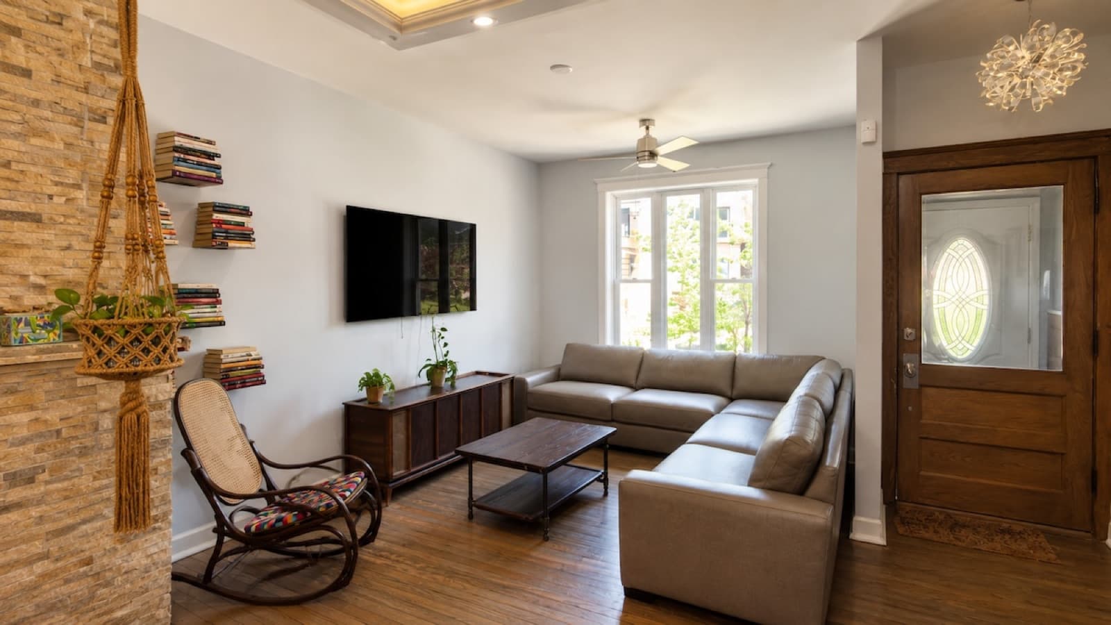 Finished living room with hardwood floors, stone fireplace wall, and clean paint
